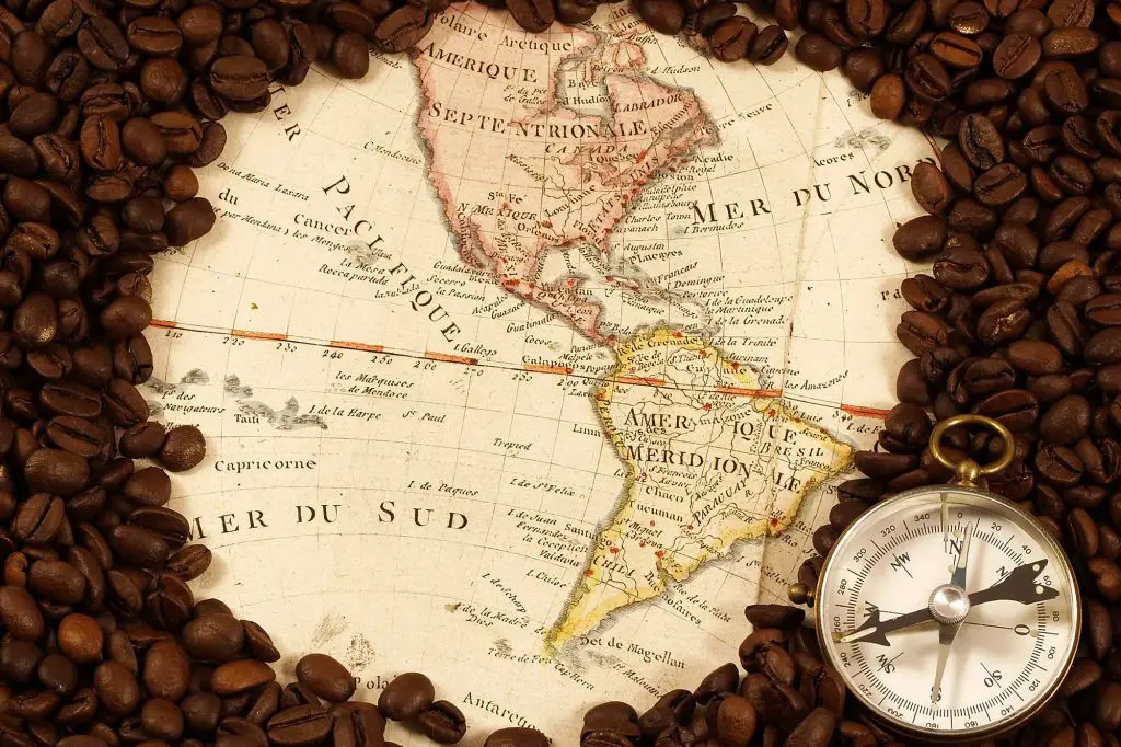Map of the North and South America encircled with roasted coffee beans.